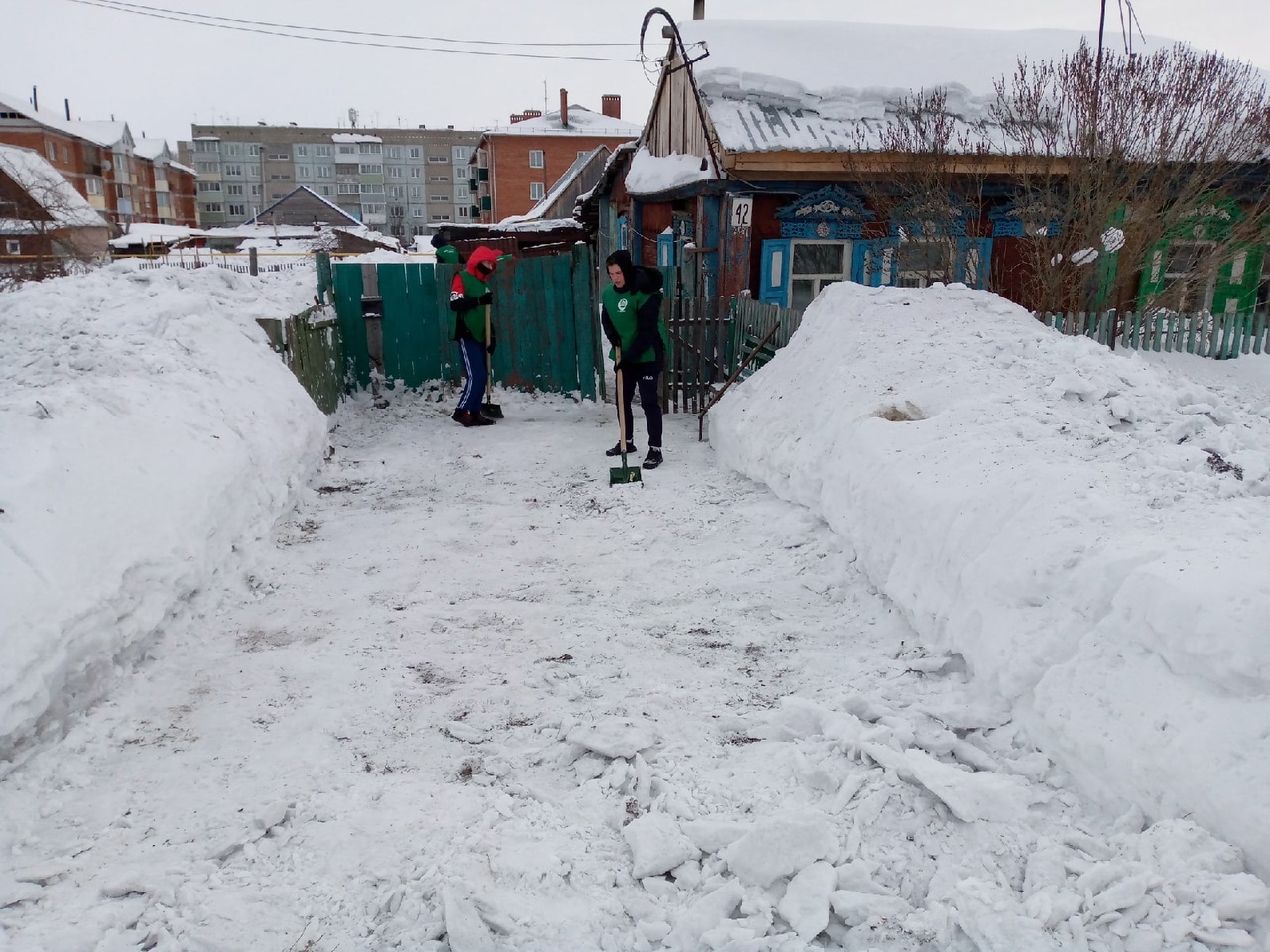 Снег во дворе. Расчищенная дорожка. Снег скапливается.